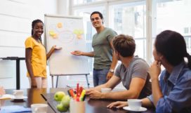 Graphic designers discussing on whiteboard with their colleagues